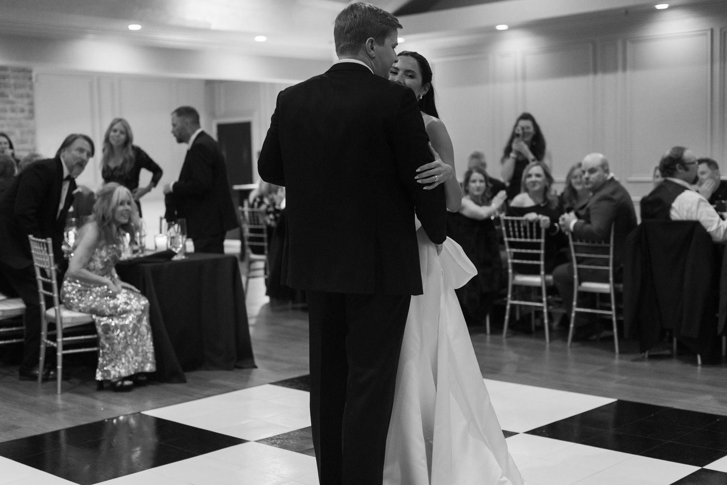 Black and white panorama of a wedding reception dance floor with couples dancing in formal attire.