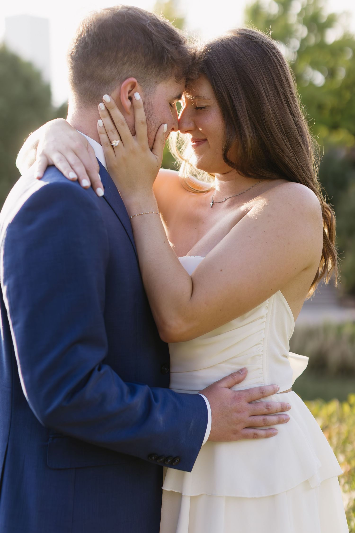 An intimate wedding photoshoot showing close embraces between a couple in white and navy attire.