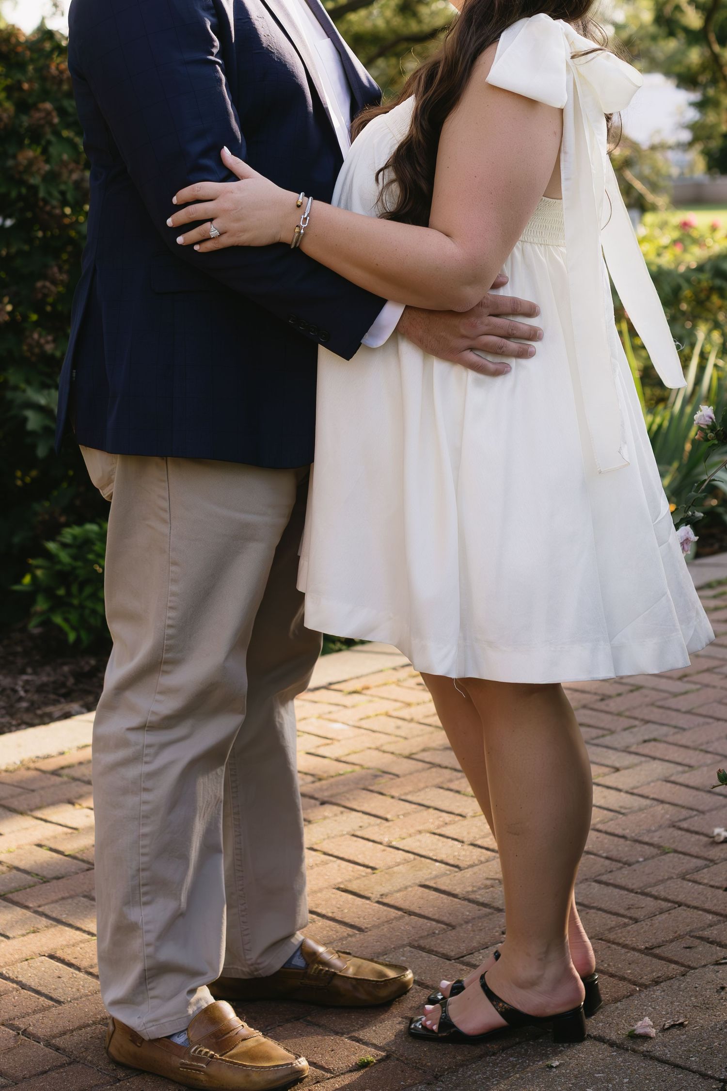 Close-up shots of a couple embracing on brick pavement in formal wedding attire.