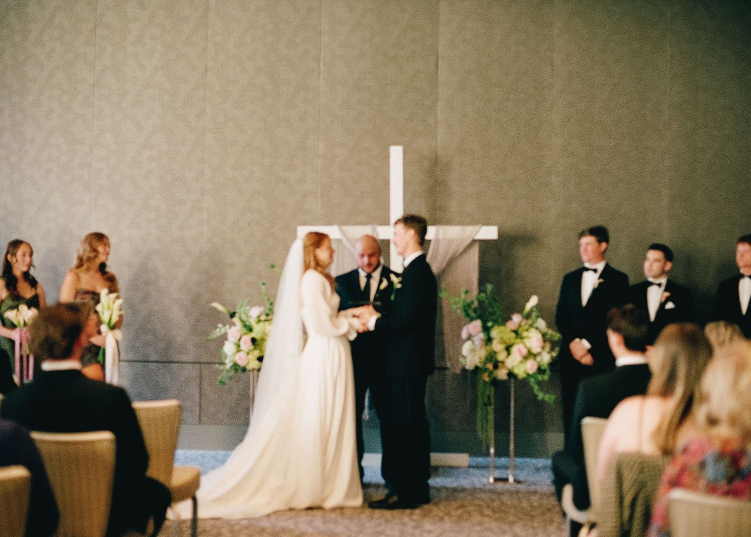 Wedding reception scene with guests gathered in an elegant ballroom setting.