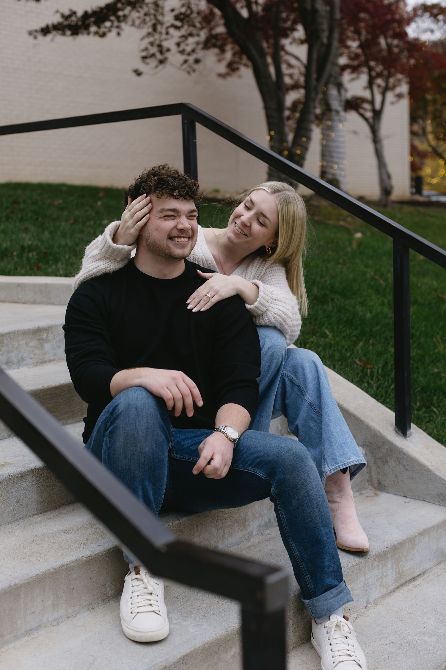 A couple sharing joyful moments on concrete steps.