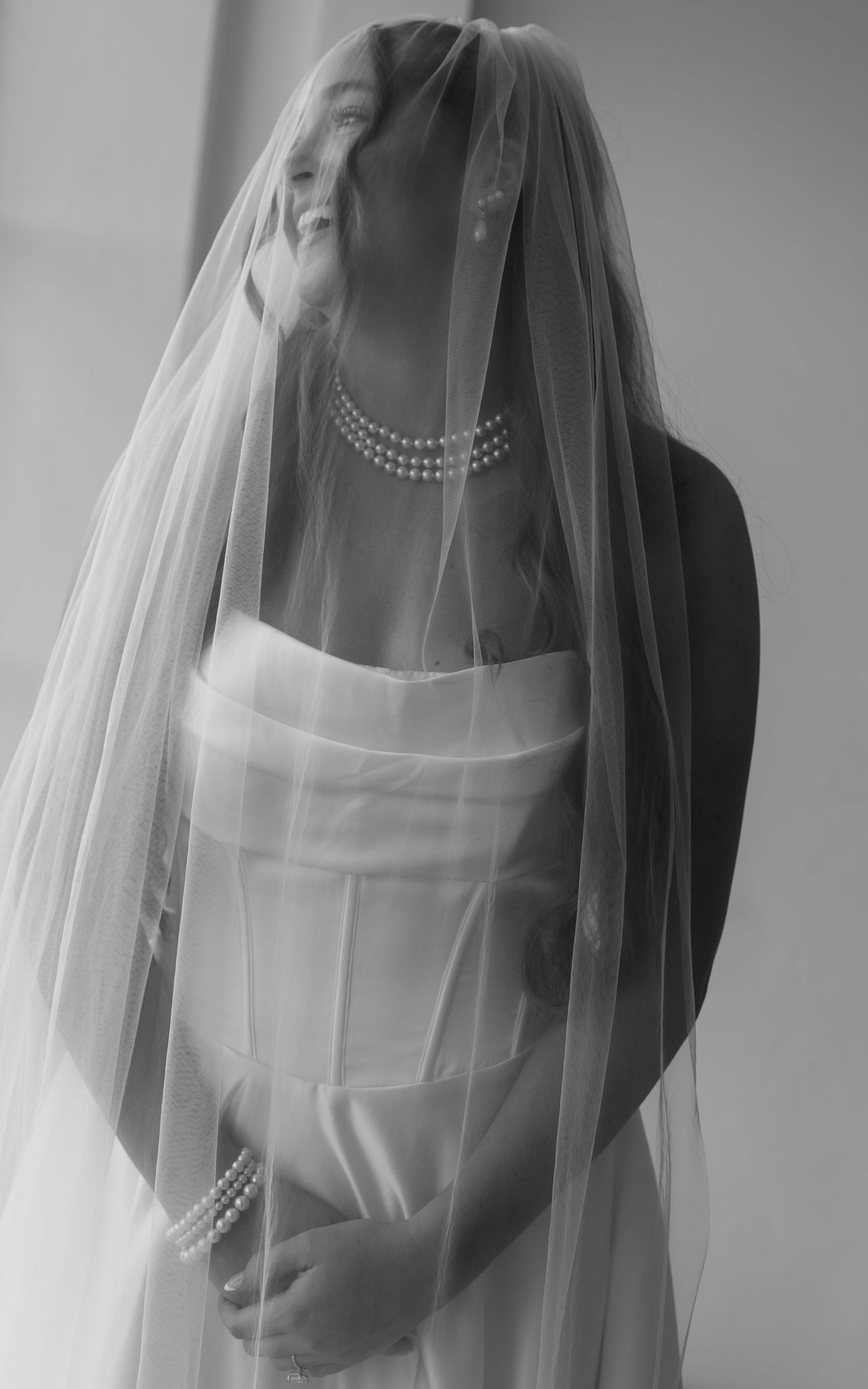 Ethereal black and white portrait of a bride in her wedding gown and veil.