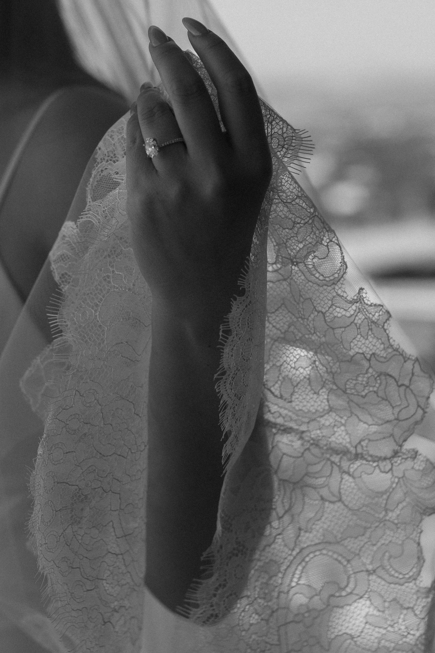 Close-up detail of delicate white lace fabric in black and white photography.