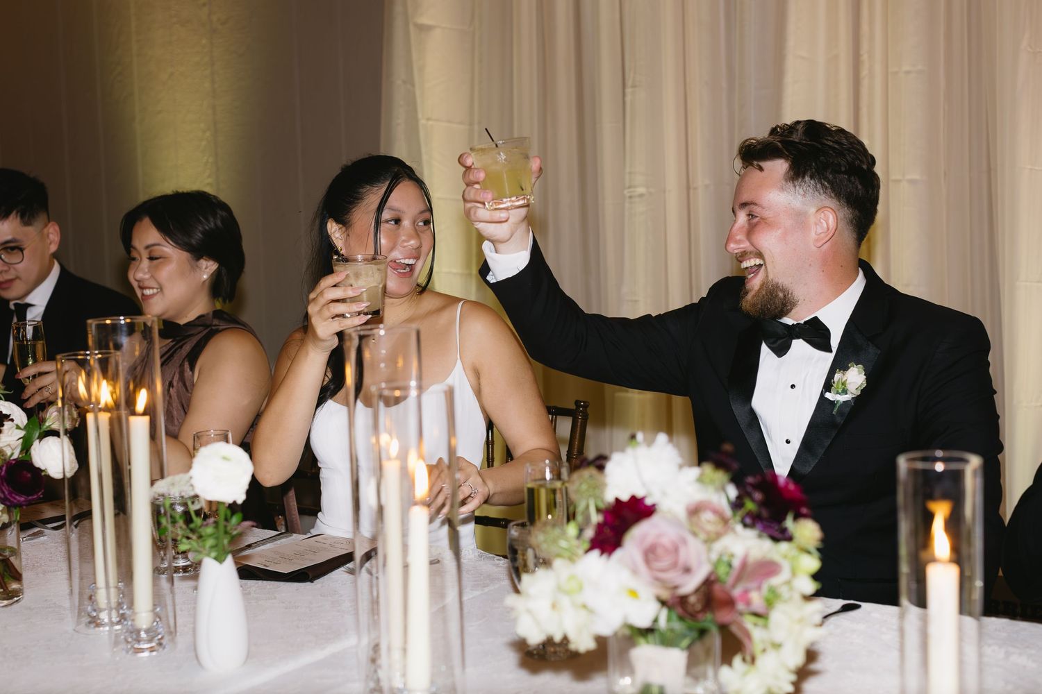 Wedding reception table decorated with elegant candles and floral arrangements.