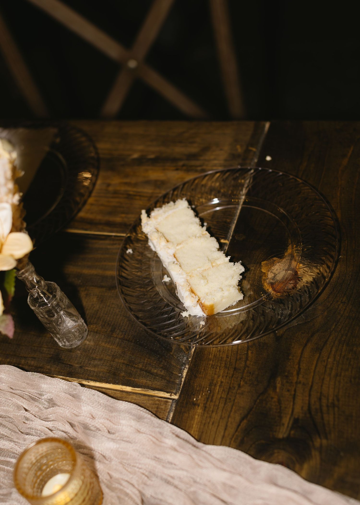 White floral decorations and candles arranged on a rustic wooden surface.