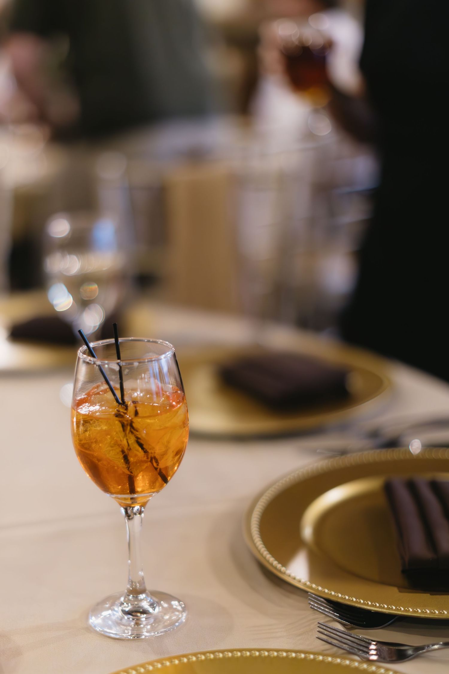 Amber-colored cocktails in crystal glasses on an elegant dining table setting.