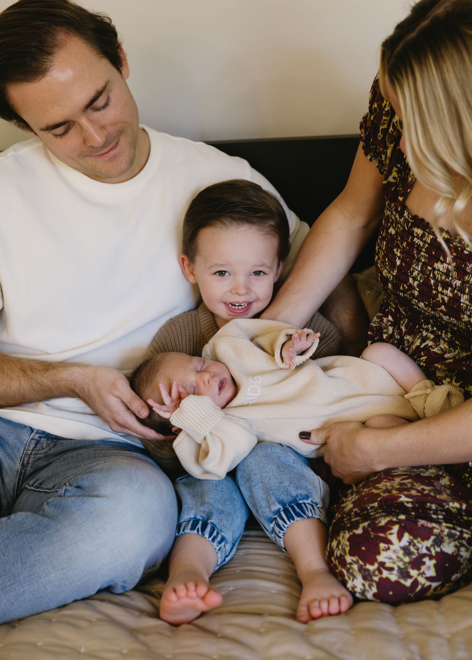 Intimate family moments captured on couch with floral dress and casual attire.