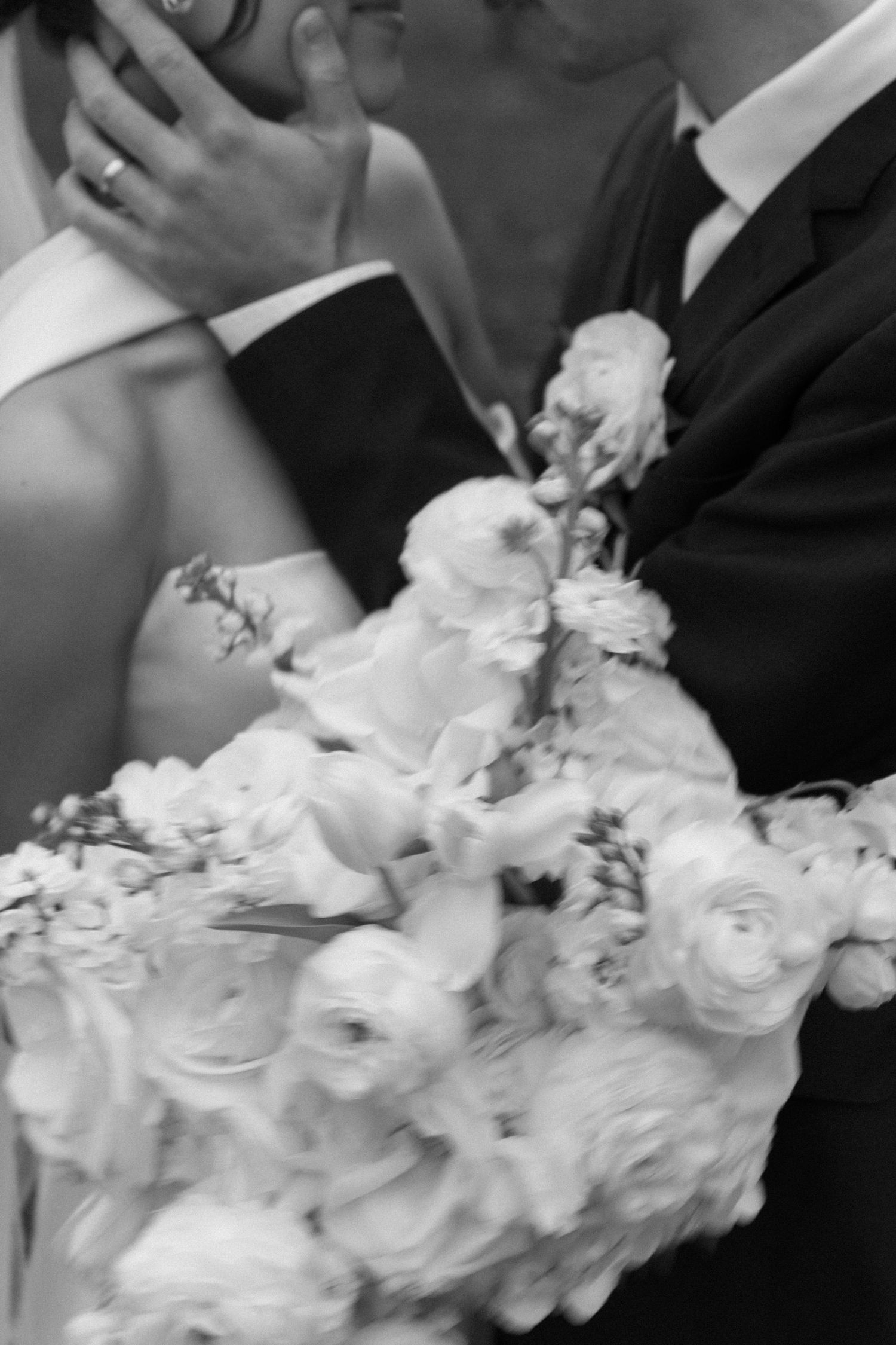 Close-up details of white wedding bouquet with elegant floral arrangements.