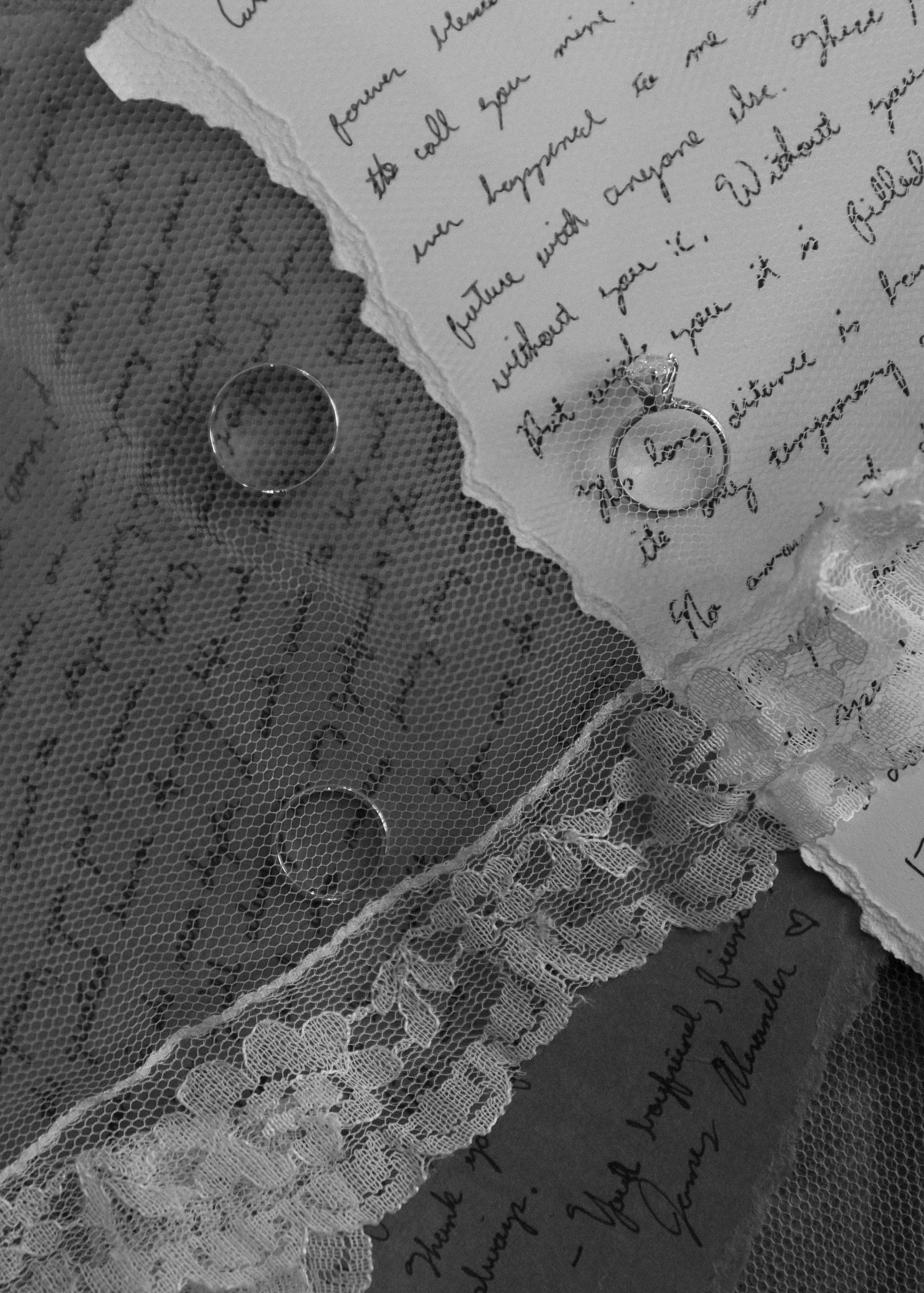 Vintage handwritten letter with torn edges and decorative lace detail on textured dark fabric.