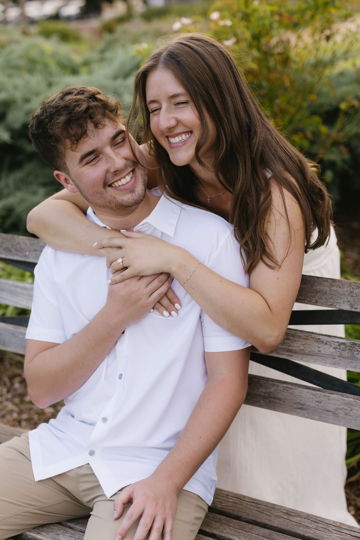 A candid moment of joy and laughter shared on a wooden park bench.
