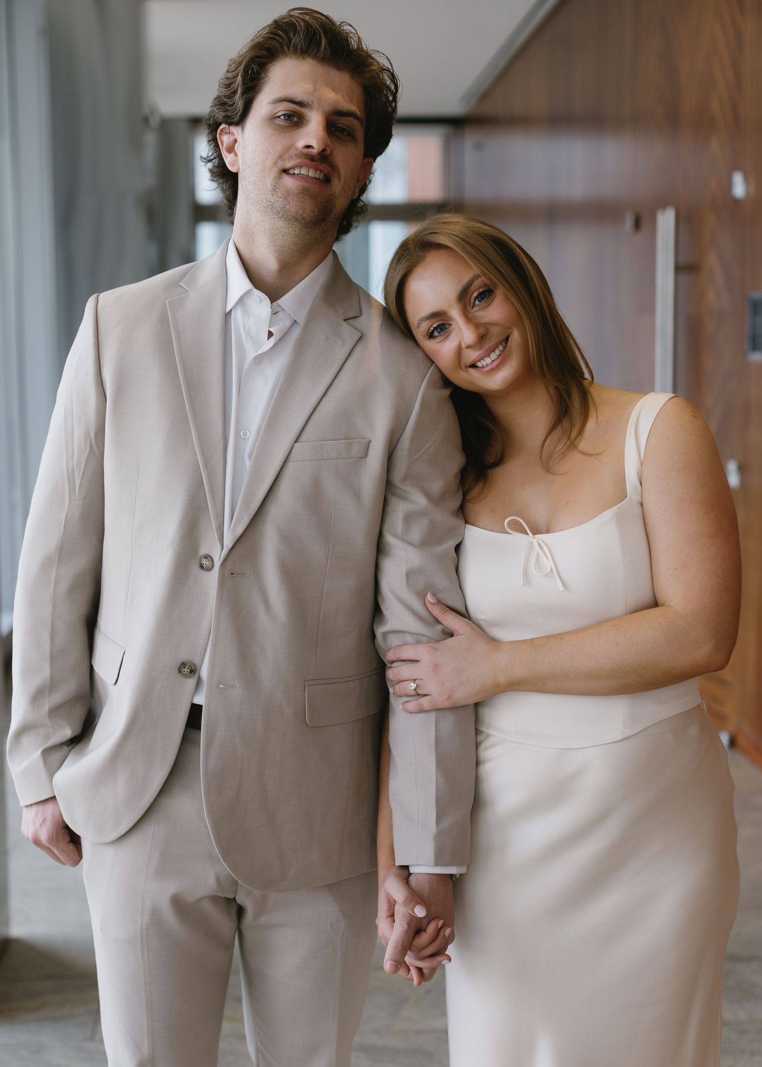 A couple in coordinating formal wear sharing tender moments in an indoor setting.