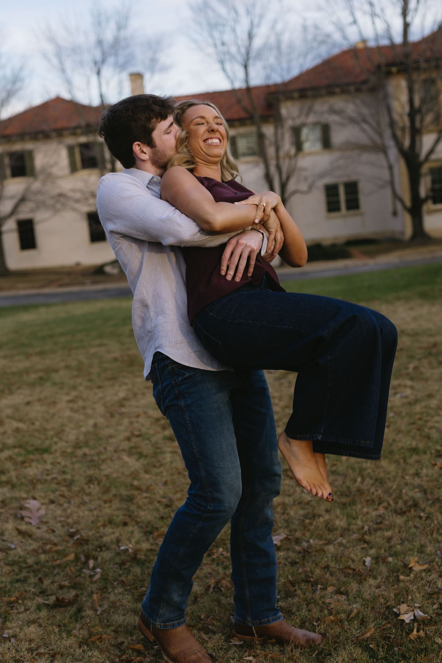 Romantic outdoor portrait of a couple dancing and dipping on a winter lawn.