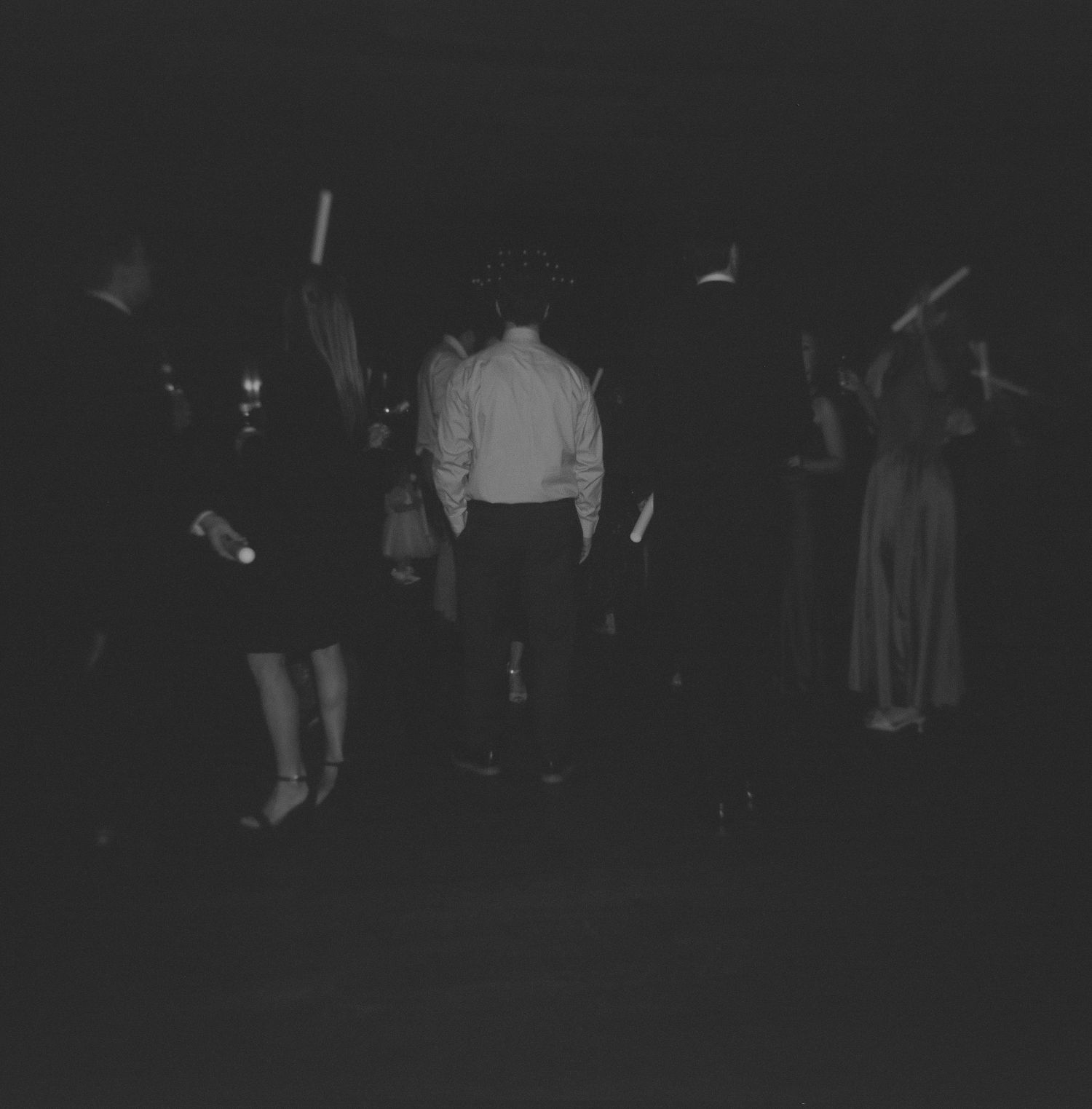 Dark reception dance floor scene with guests in formal attire.