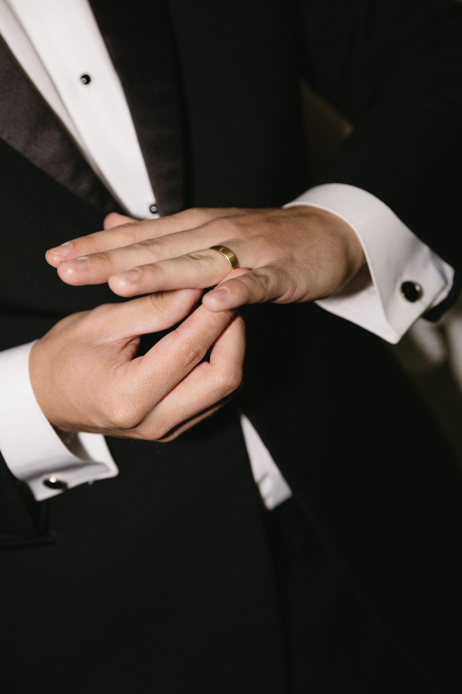 Close-up of hands exchanging rings during wedding ceremony.