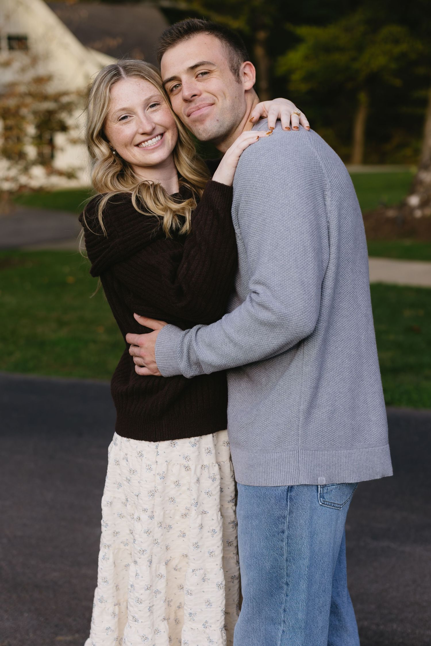 Couple shares affectionate moments outdoors in coordinated casual outfits.