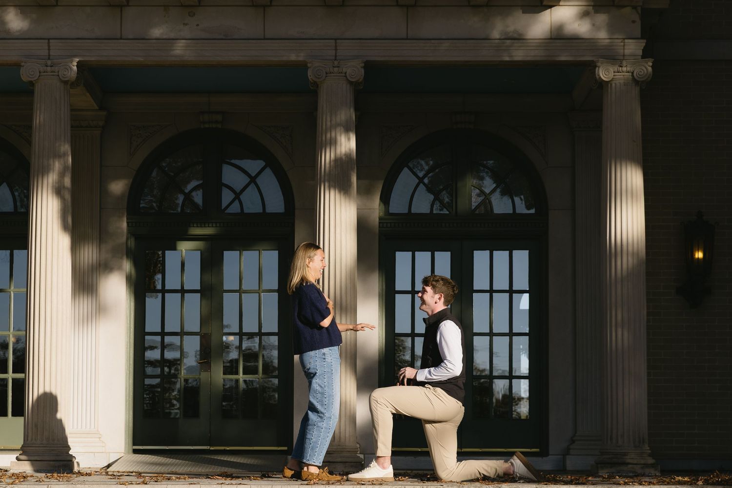 A special moment captured as someone proposes on one knee outside a historic building.