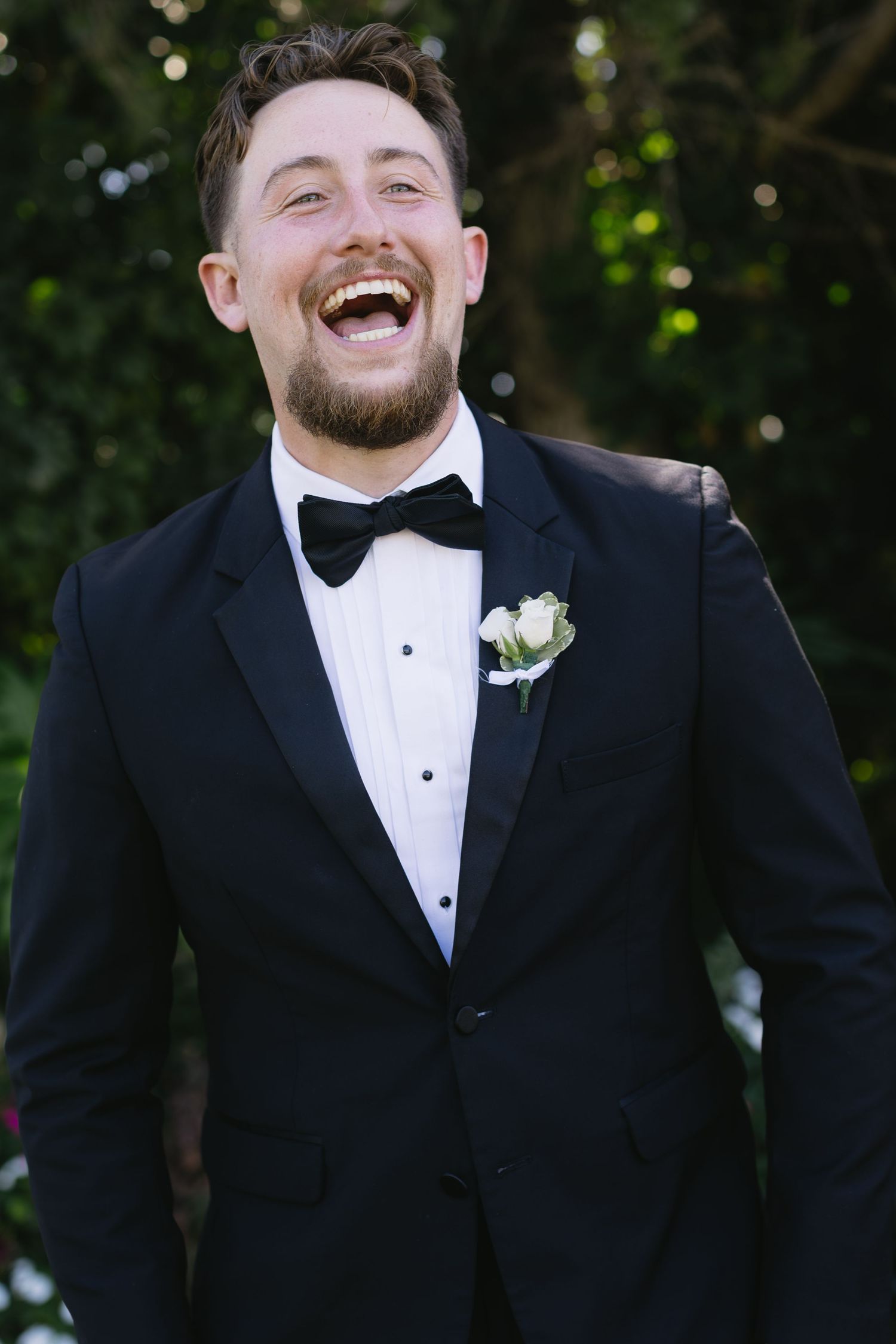 Series of candid expressions of a groom in a black tuxedo and bowtie.