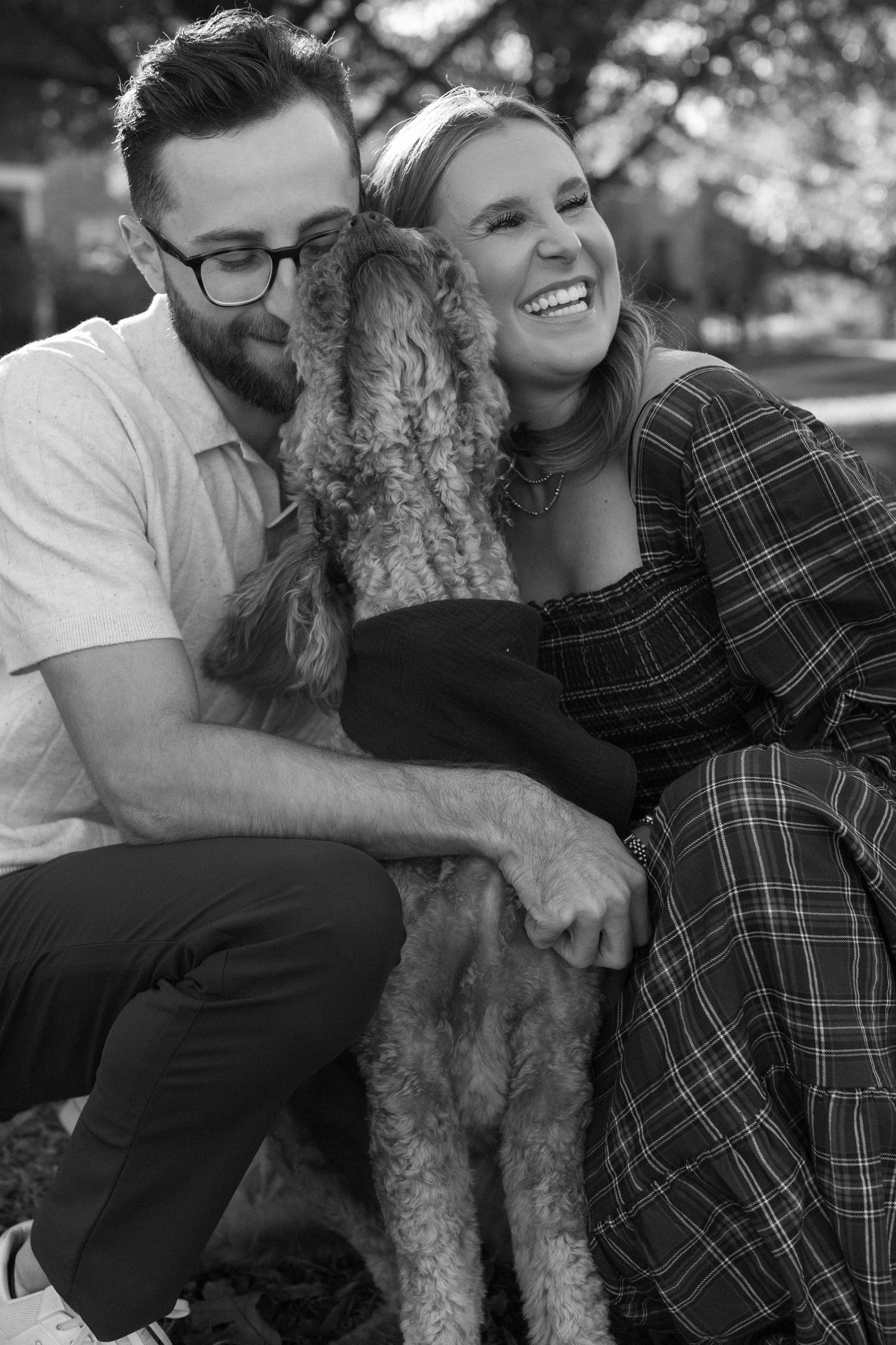 Black and white photos show tender moments between a couple and their curly-haired dog outdoors.