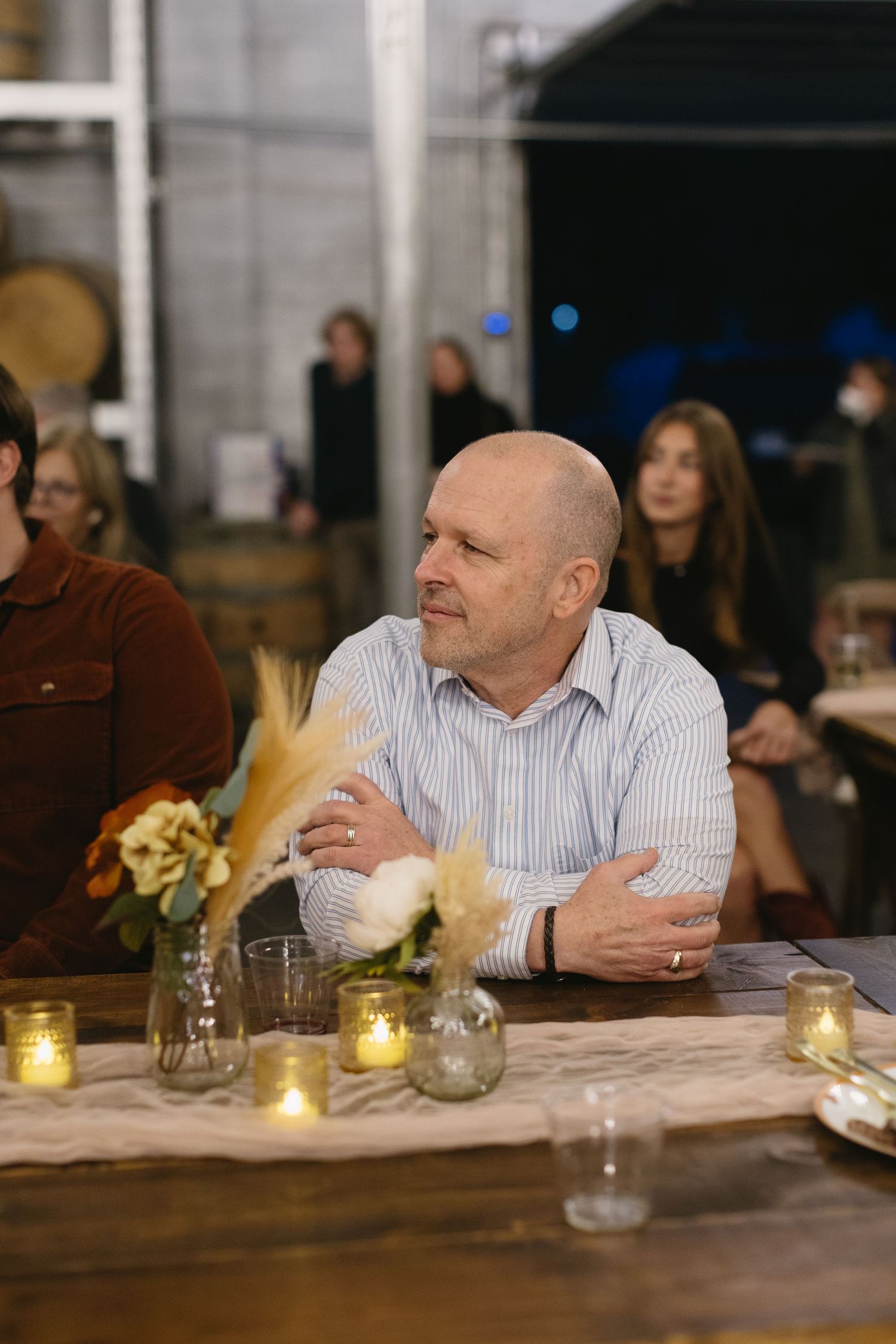 A guest relaxes at a candlelit table during an evening event.