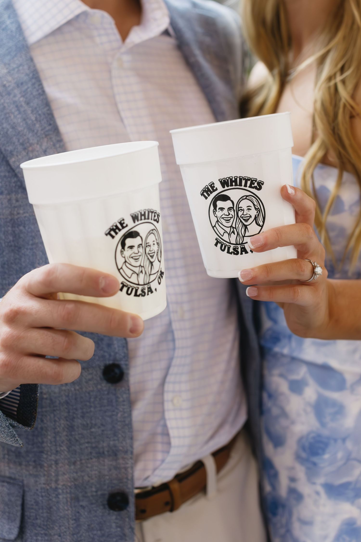 A row of disposable coffee cups with vintage-style logo designs being held up.