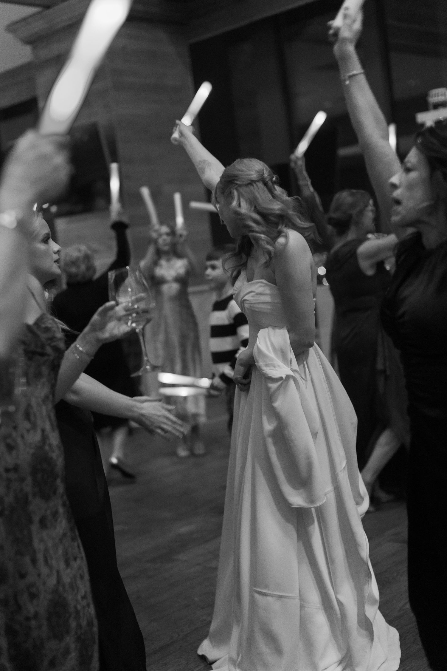 Wedding guests dance together on a crowded dance floor during a celebration.