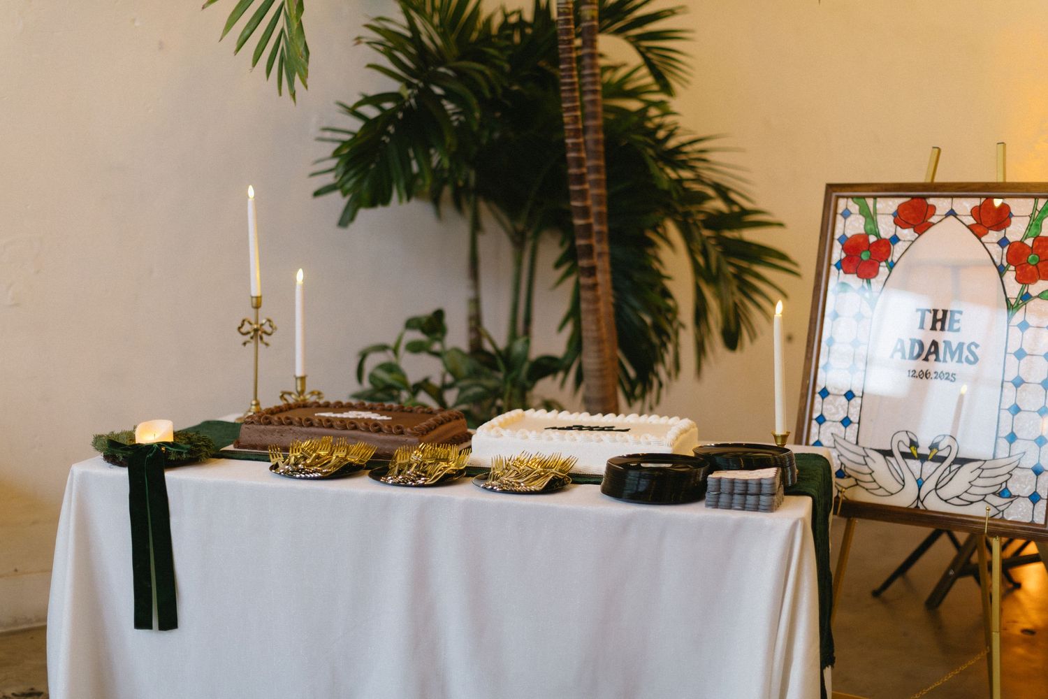 Wedding reception buffet table with white tablecloth and palm decorations.