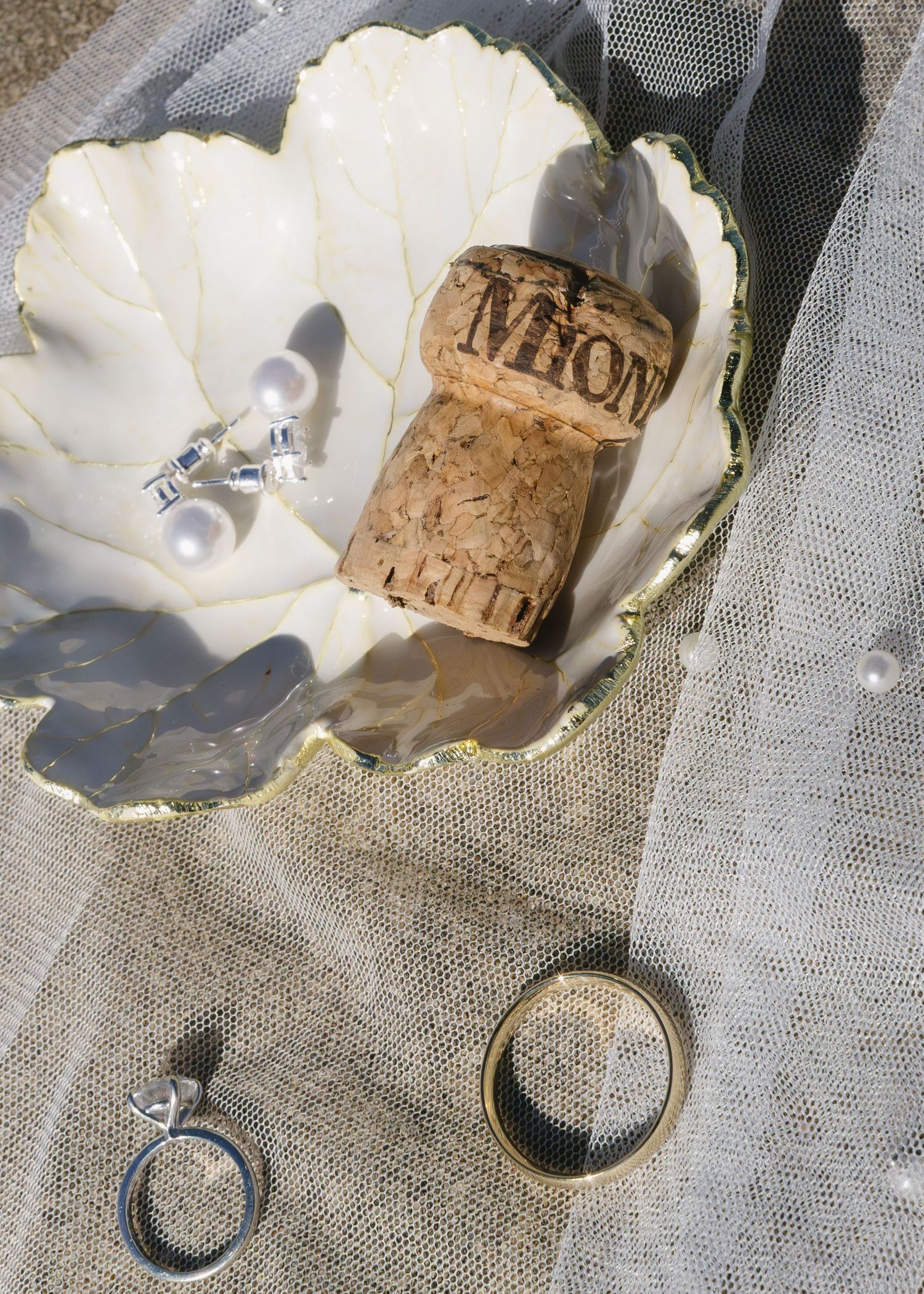 A series of photographs showing a pearl oyster shell being opened to reveal a cork stopper inside.