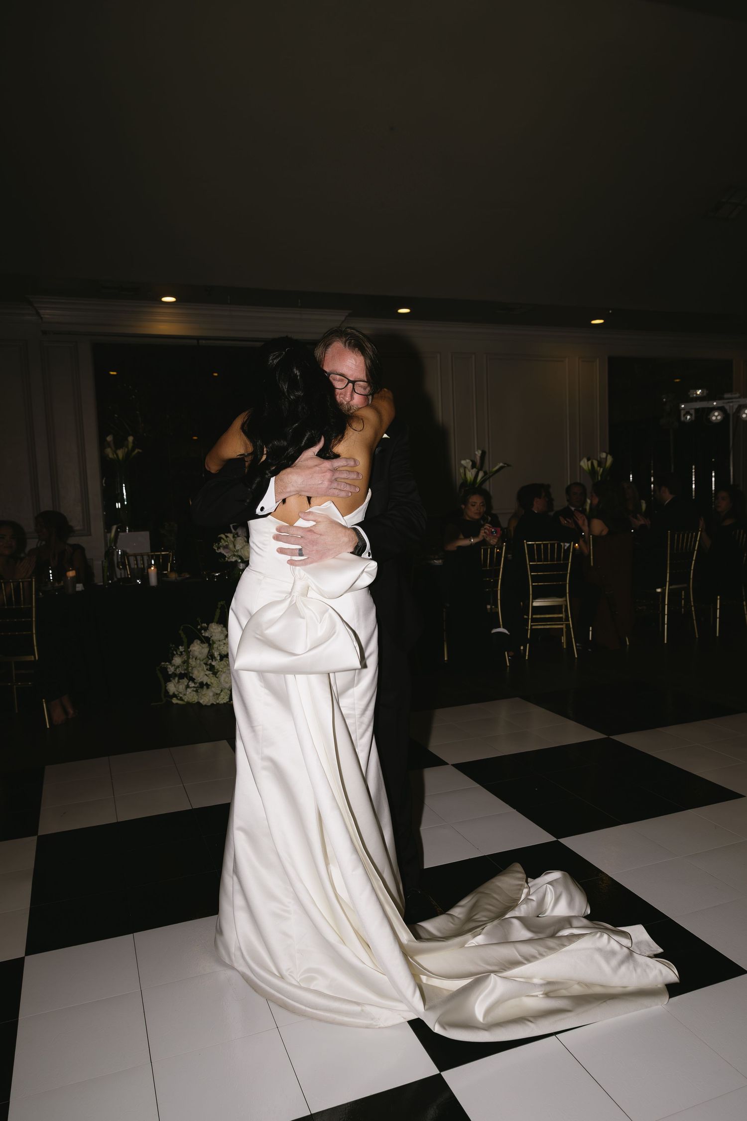 Black and white checkered dance floor with wedding celebration in progress.