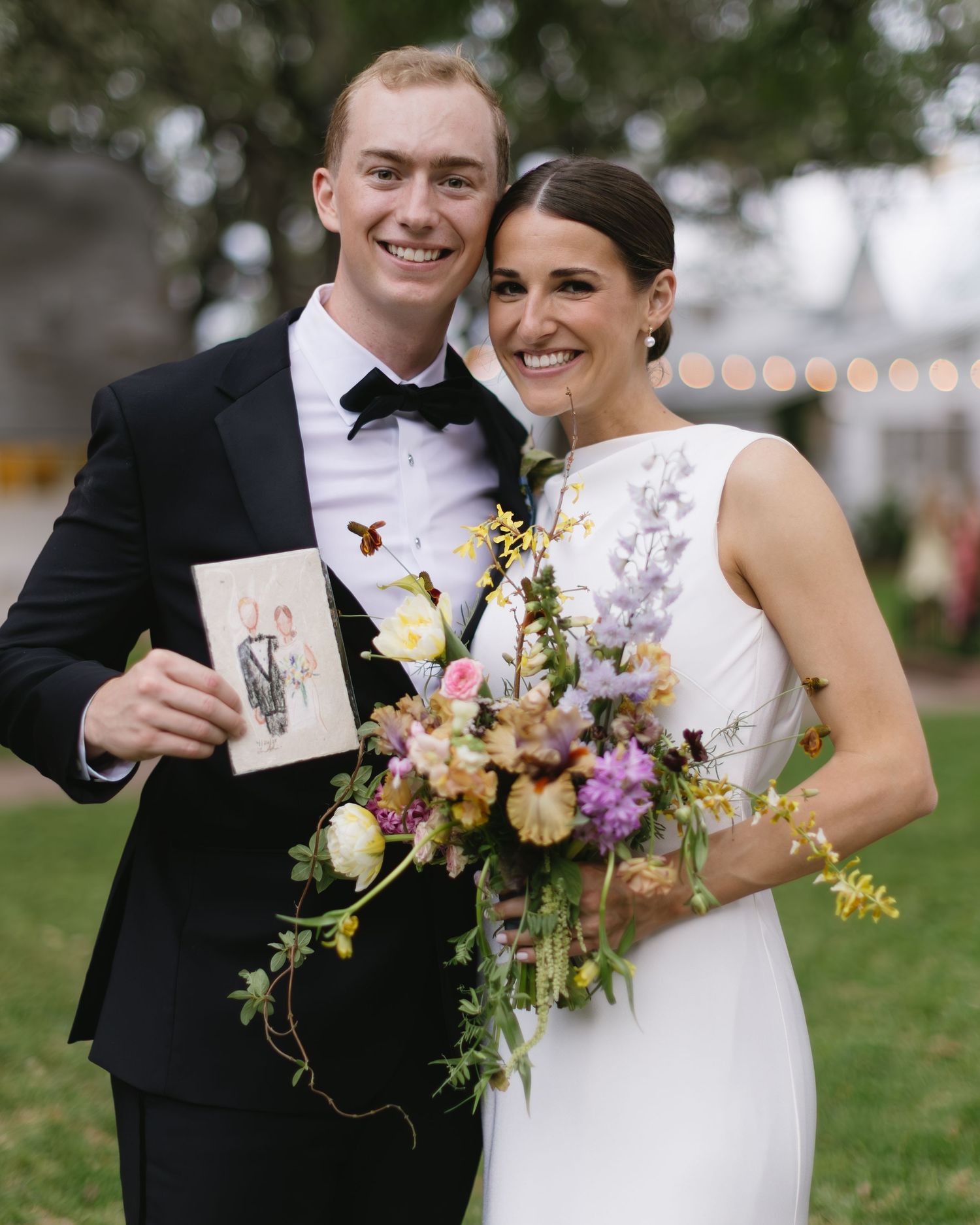 Wedding couple and floral bouquet with wildflowers and artistic card.