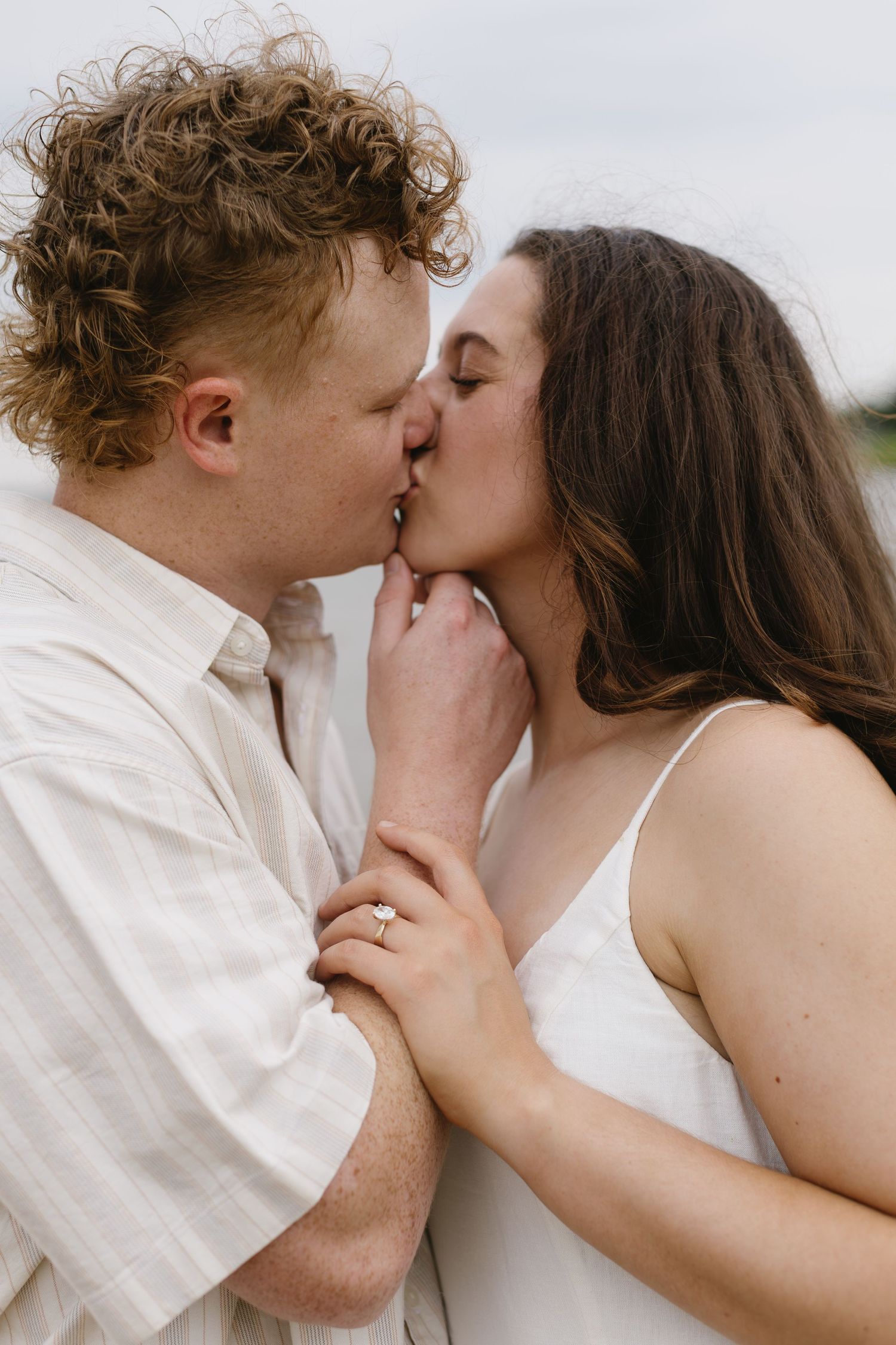 A romantic close-up series of a couple sharing tender kisses while wearing white clothing.