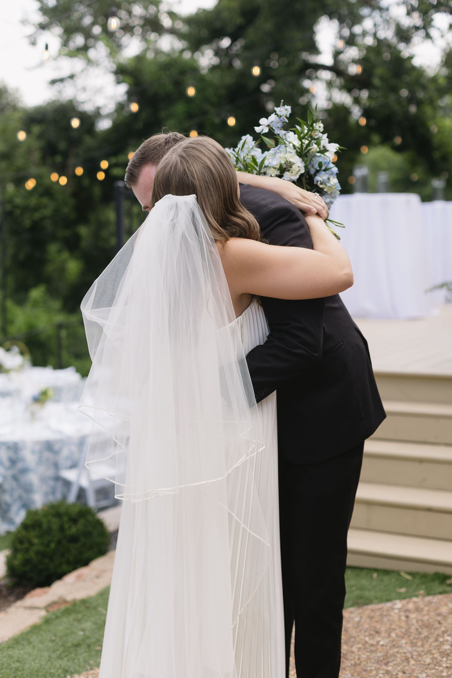 Tender embrace captured during outdoor wedding ceremony.