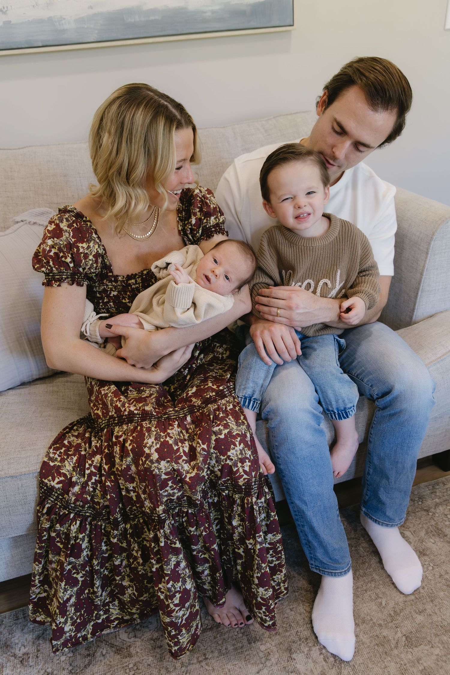 Family sitting together on a couch sharing tender moments in casual attire.
