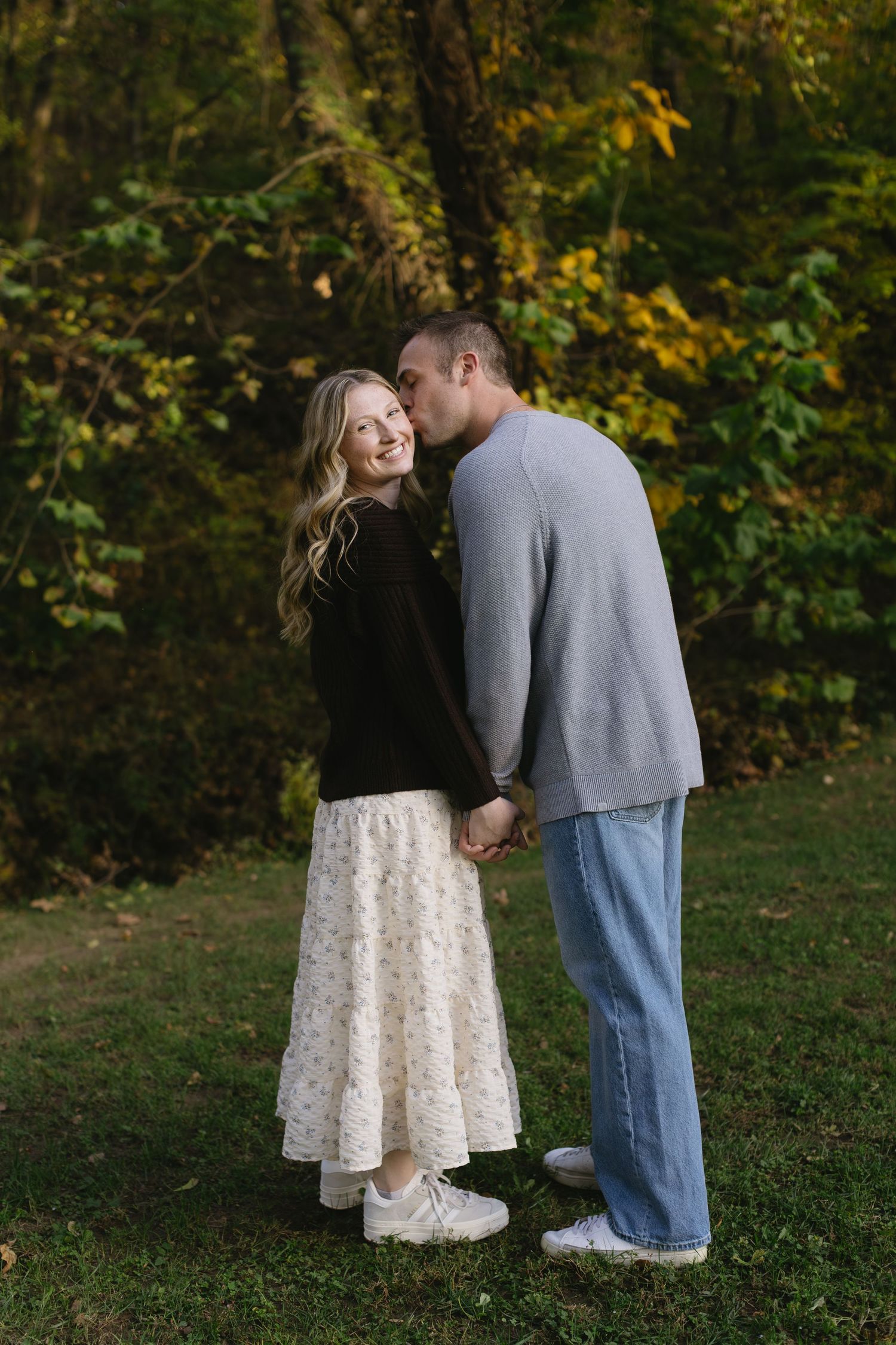 Romantic outdoor photoshoot with couple in autumn scenery.