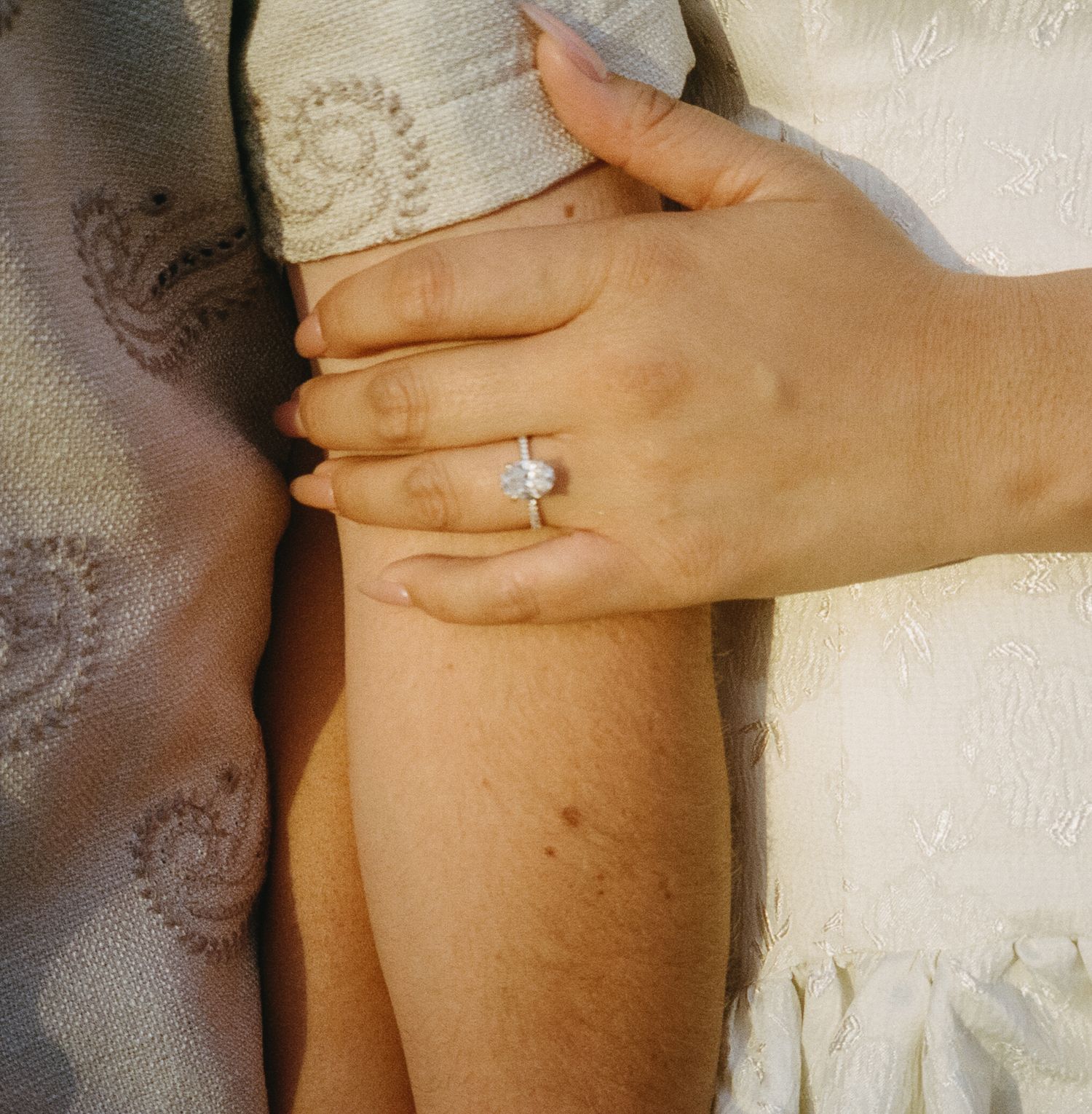 Close-up series showing a person putting on a ring in warm natural lighting against a white background.