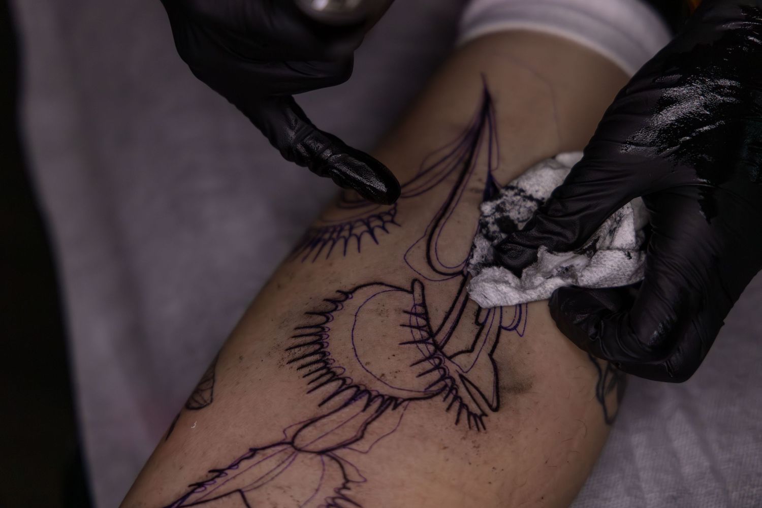 Close-up shot of Ren Abate (Ren In Black) tattooing a client