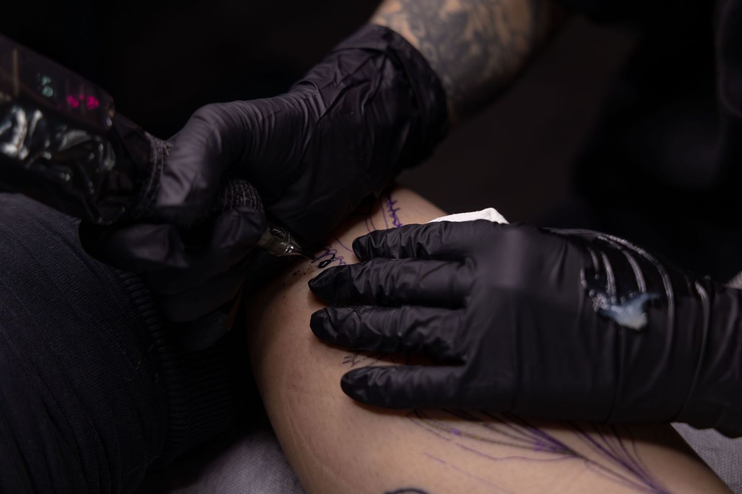 Close-up shot of Ren Abate (Ren In Black) tattooing a client