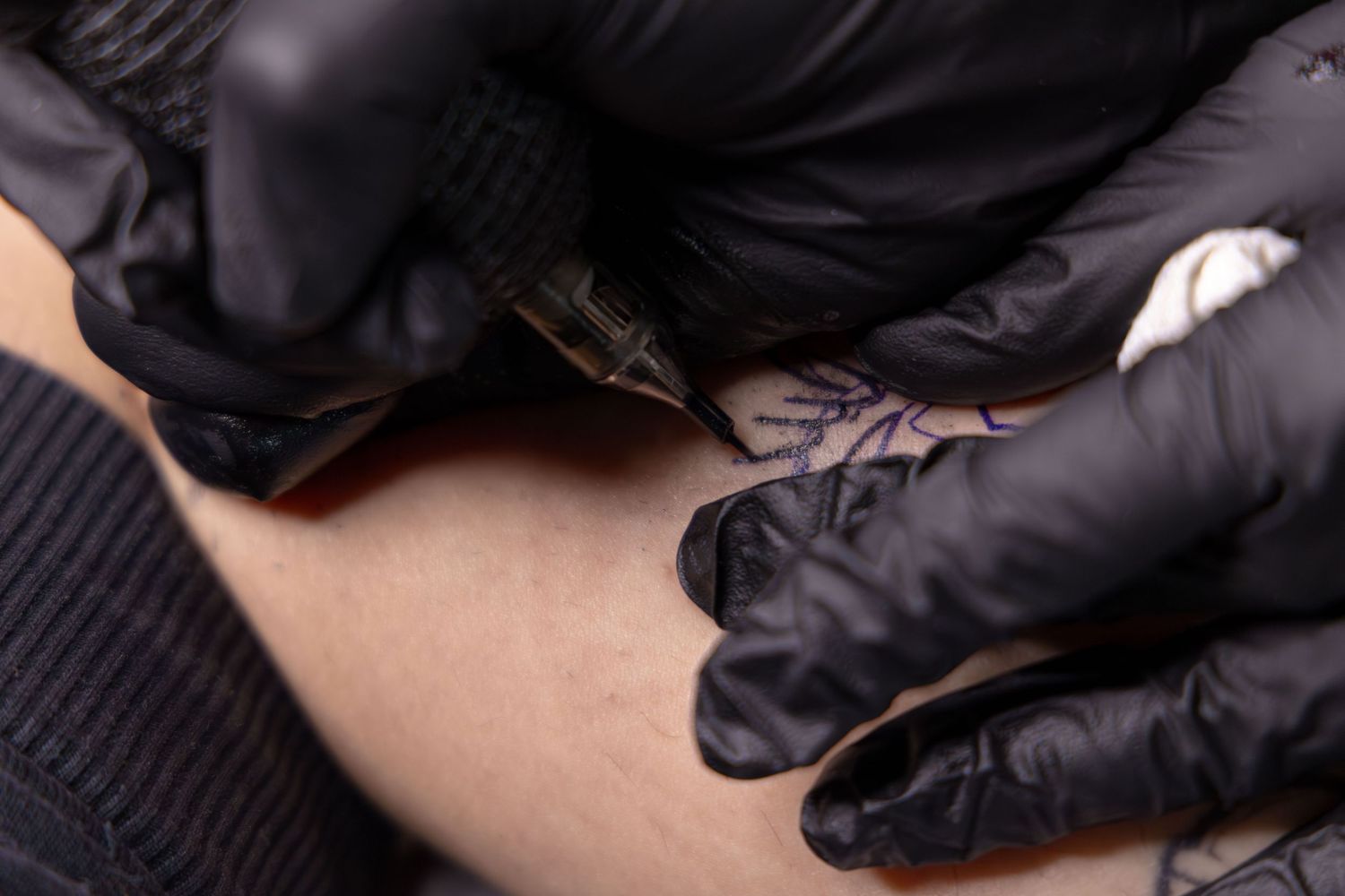 Close-up shot of Ren Abate (Ren In Black) tattooing a client