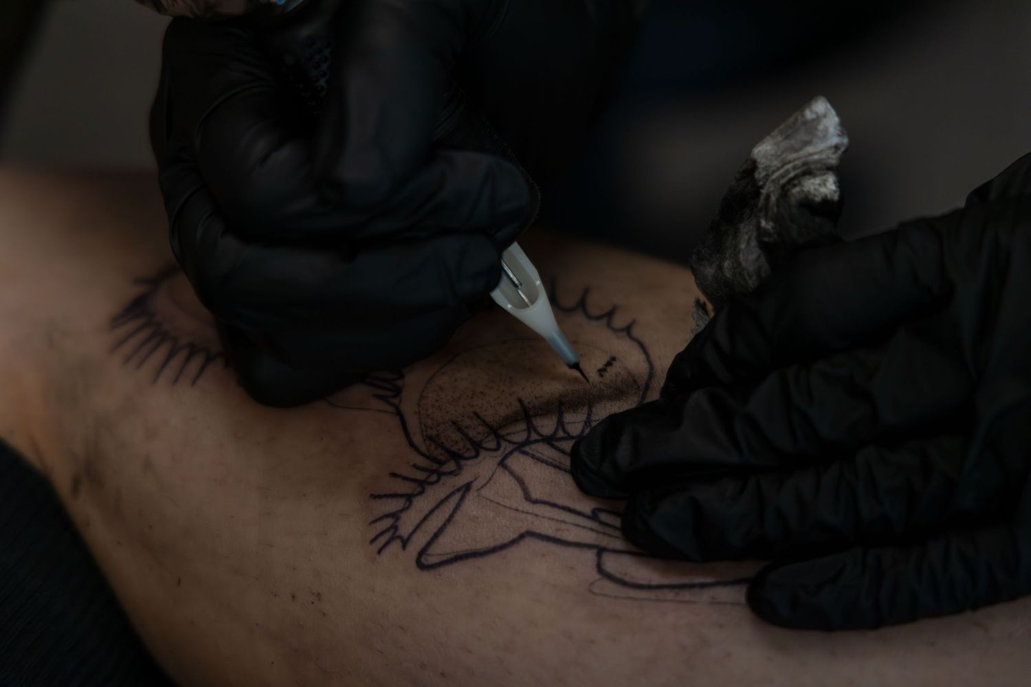Close-up shot of Ren Abate (Ren In Black) tattooing a client