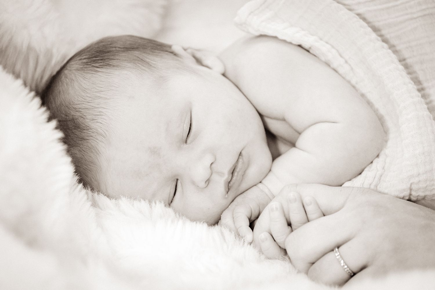 New born kuvaus vauvasta joka nukkuu viltillä