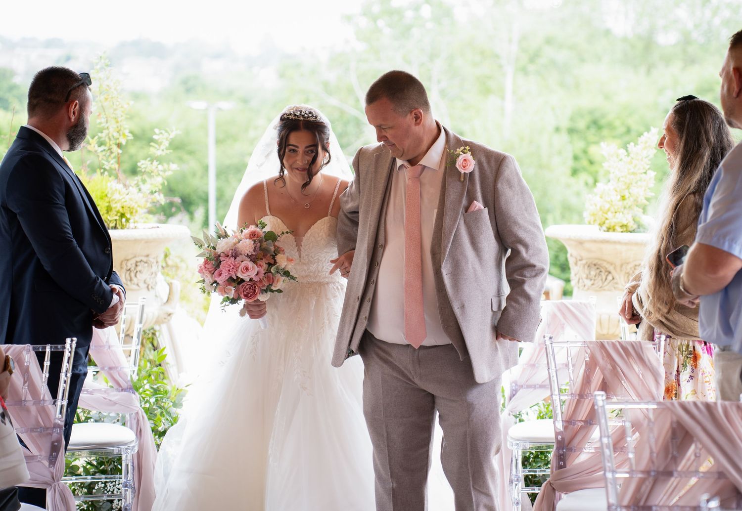 Bride and groom walking down the aisle during outdoor wedding ceremony.
