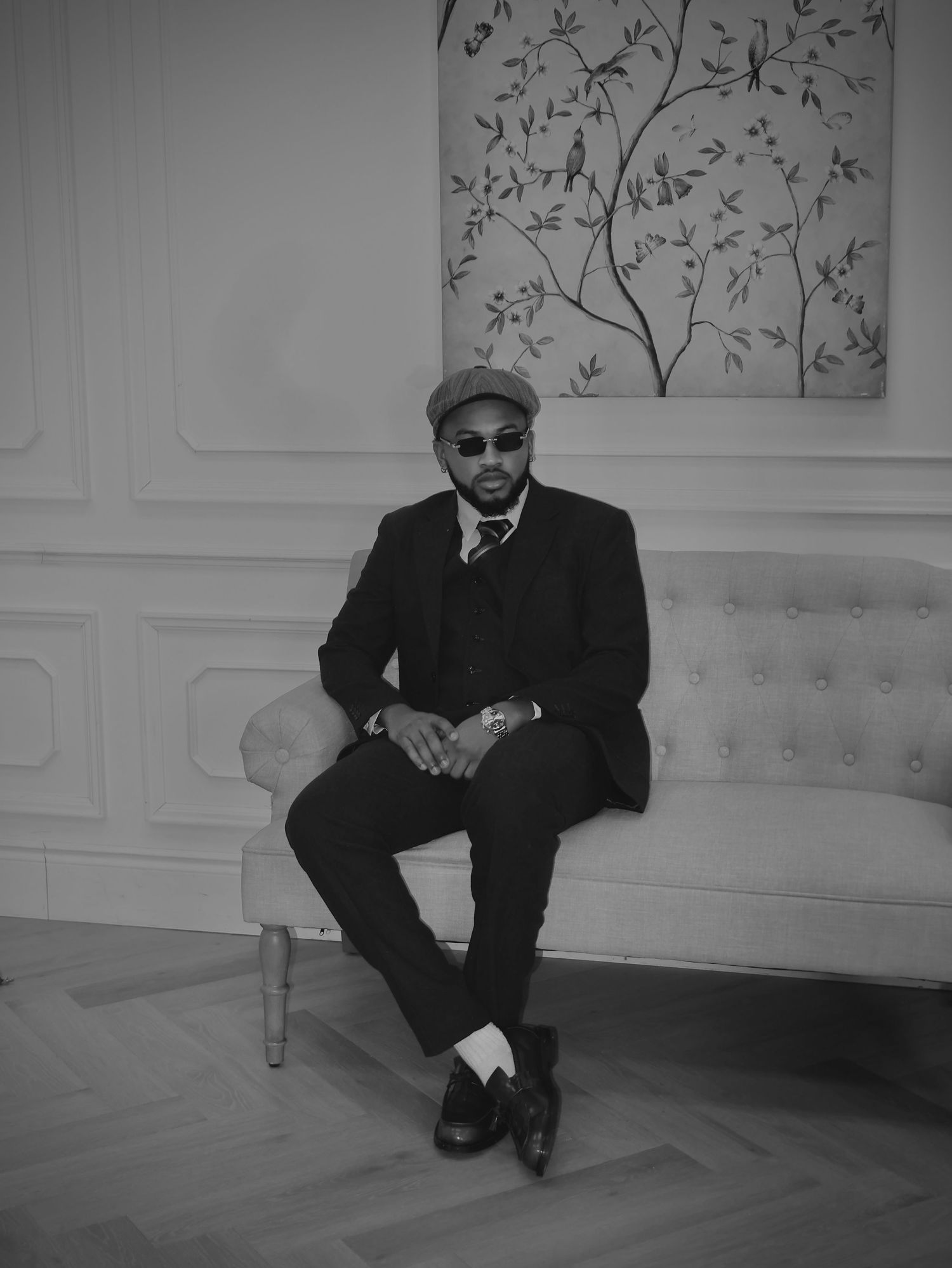 Man wearing suit sitting down on a sofa, picture style black and white
