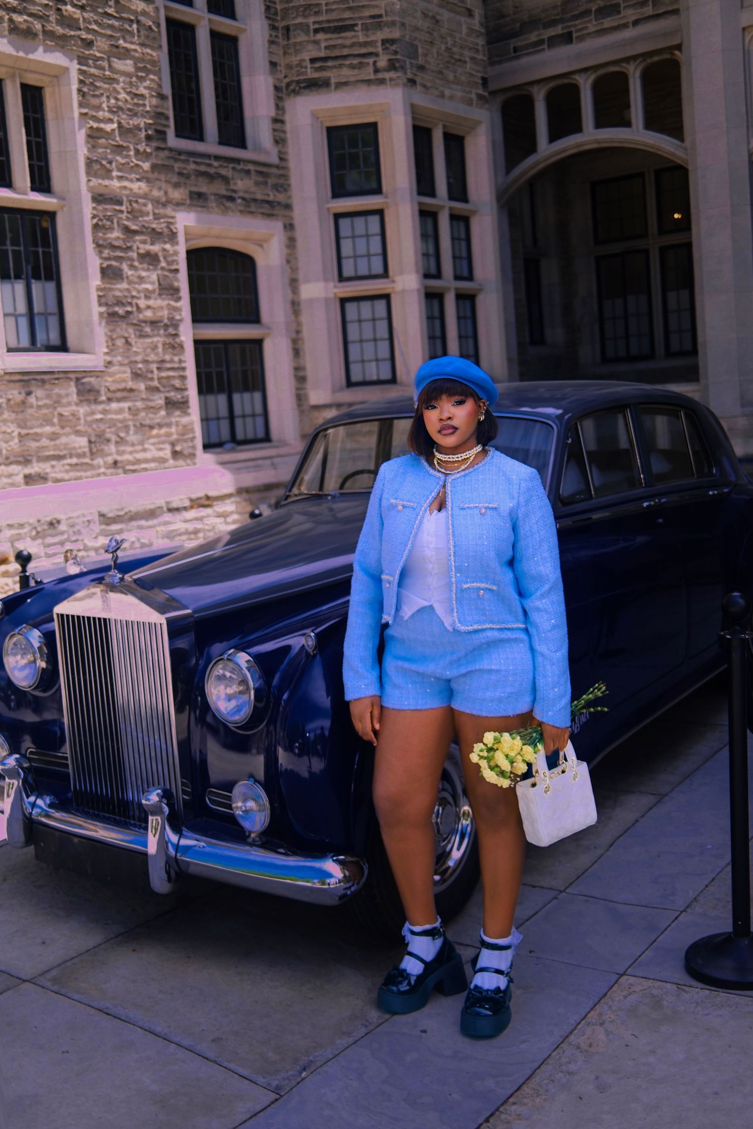 Lady in blue standing in front of a luxury car