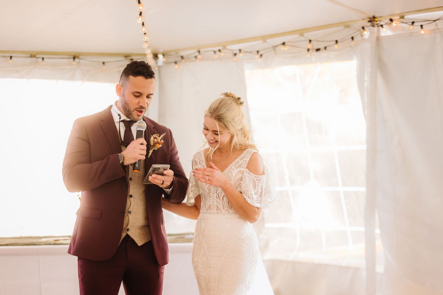 Wedding celebration under string lights with people dancing and enjoying festivities.