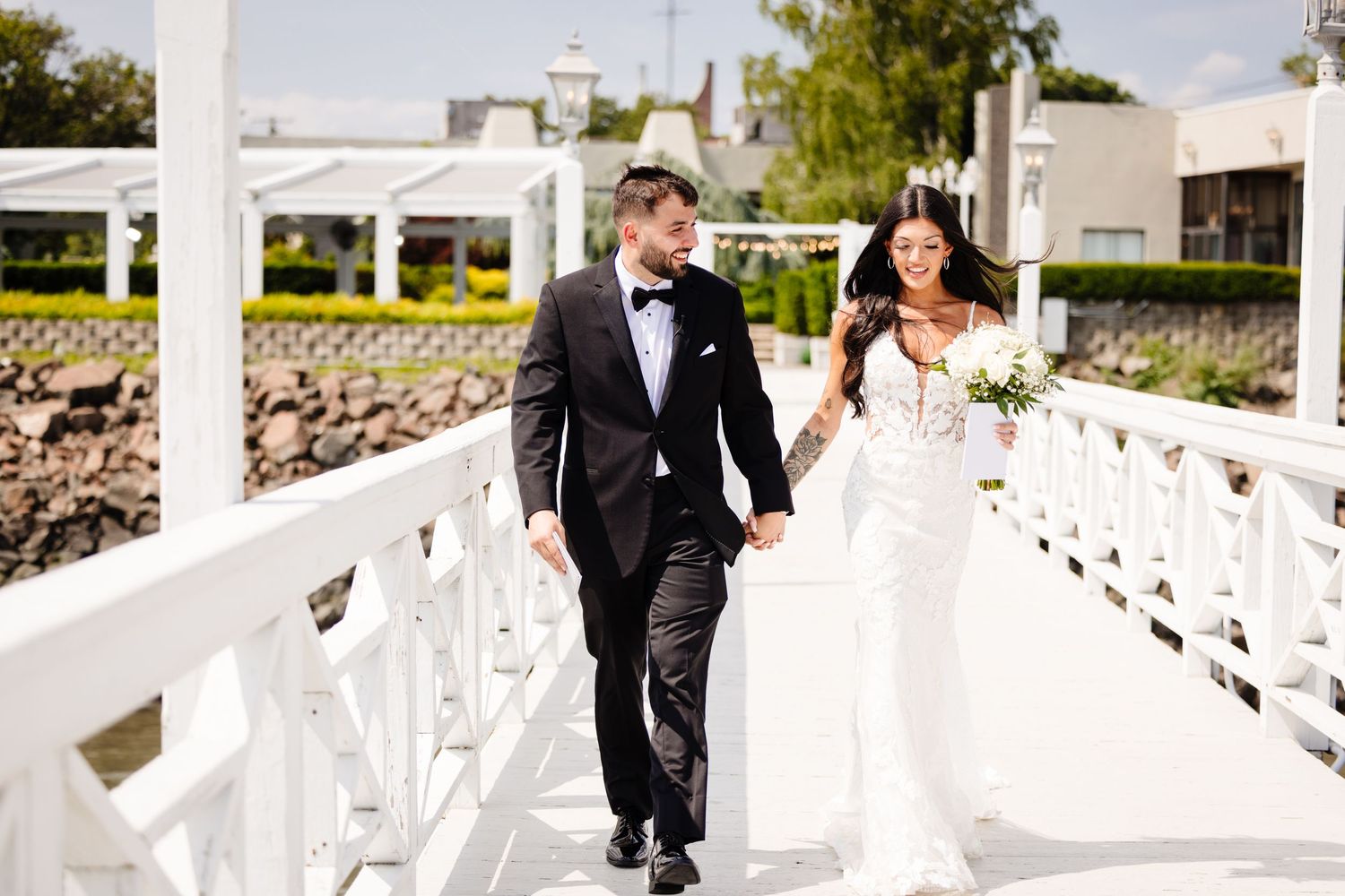 White coastal wedding venue with decorative railings overlooking the water on a sunny day.