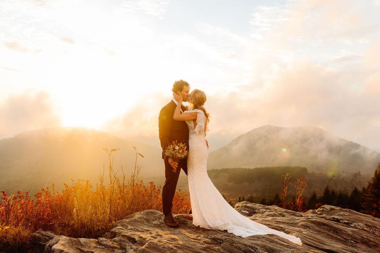 A romantic sunset moment on a rocky mountain overlook with autumn colors in the landscape.