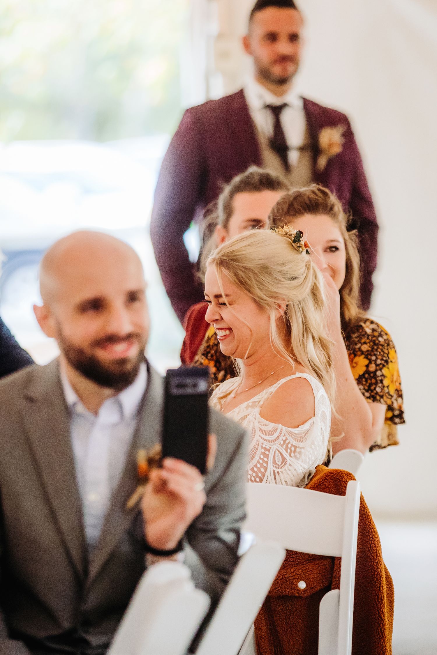 Candid moments of wedding guests laughing and celebrating in a bright indoor venue.