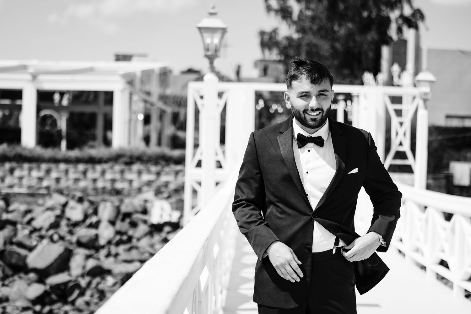 Couple exchanging vows during an intimate waterfront wedding ceremony with white pergola overhead.
