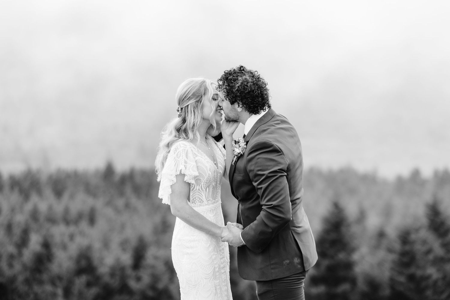 A tender black and white wedding moment captured against a mountainous backdrop.