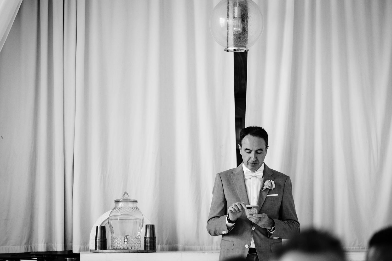 Black and white photo of someone reading from cards at a wedding reception.