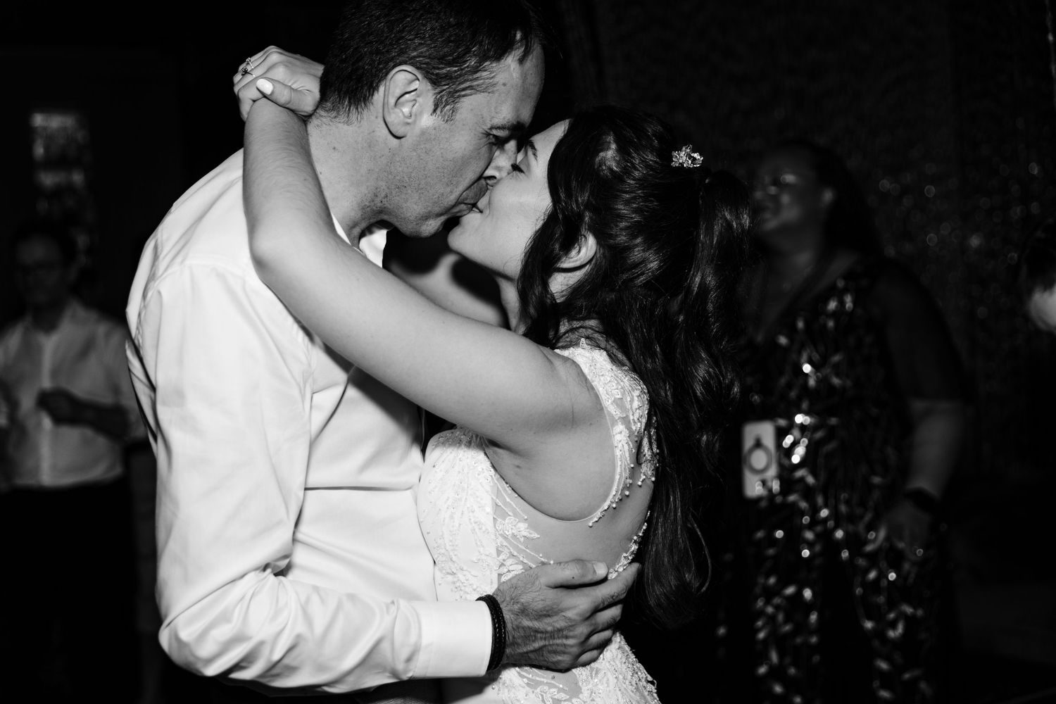 Intimate black and white photo of a couple sharing their first dance at a wedding reception.